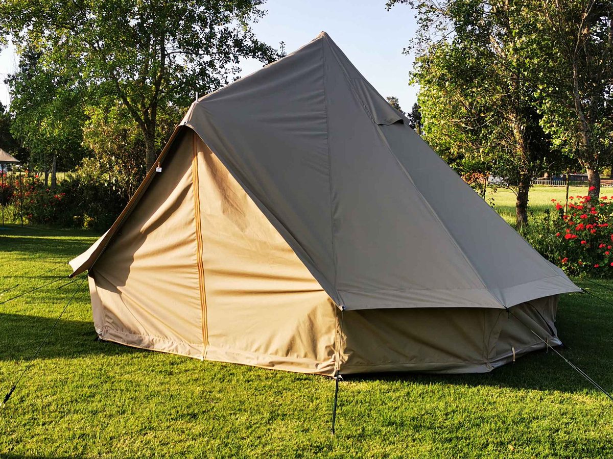 A large canvas bell tent pitched on grass