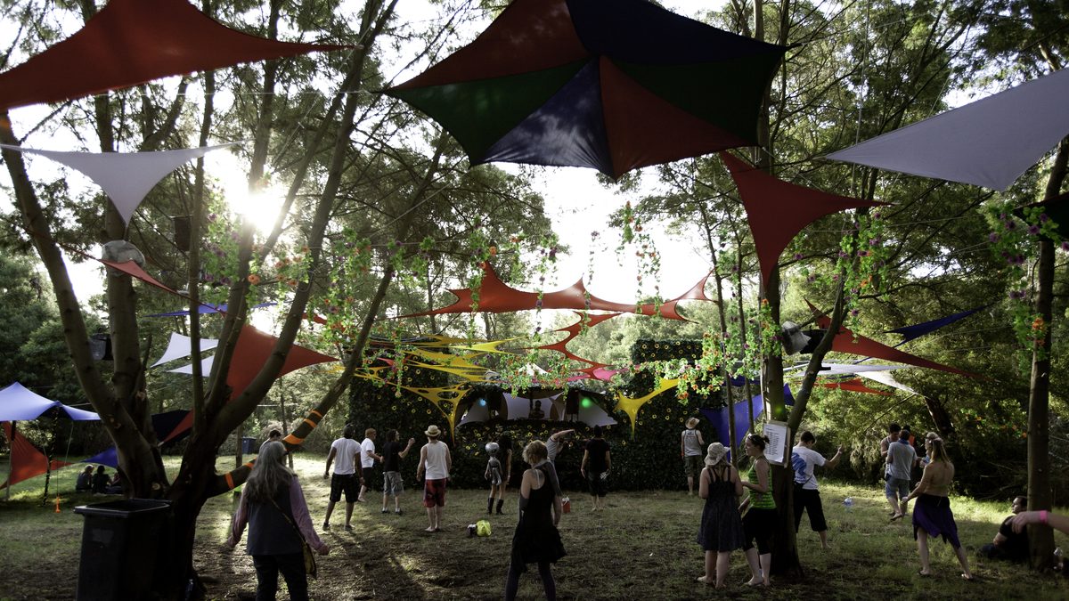 Shade sails and decor strung between the trees over the dance floor